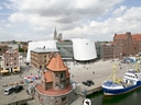 Blick auf Hafenplatz mit modernem Gebäude und Schiff in Hafenstadt.