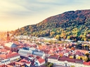 Panoramablick auf Heidelberg mit Neckar und herbstlichen Hügeln.