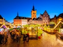 Weihnachtsmarkt am Abend mit erleuchteten Buden und historischen Gebäuden.