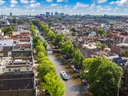 Luftaufnahme eines Kanals in einer Stadt mit Booten und Bäumen.