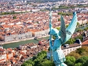 Statue mit Flügeln überblickt Stadt und Fluss.