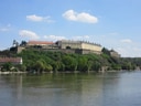 Festung auf einem Hügel am Flussufer an einem sonnigen Tag.