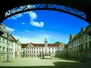 Hof eines historischen Schlosses mit blauem Himmel.