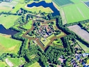 Luftaufnahme einer sternförmigen Festung mit umliegender Landschaft.