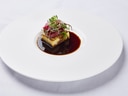 Gourmet-Vorspeise auf weissem Teller mit Sauce.