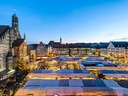 Abendansicht des Weihnachtsmarktes mit beleuchteten Ständen und Kirche in der Stadt.