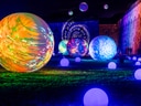 Beleuchtete Kugeln in nächtlicher Lichtinstallation.