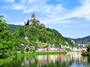 Burg auf einem Hügel über einer Stadt am Fluss.