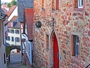 Enge gepflasterte Strasse mit historischen Fachwerkhäusern.