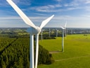 Luftaufnahme von Windkraftanlagen über grüner Landschaft.