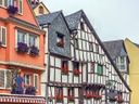 Bunte Fachwerkhäuser und Strassencafé mit Tischen und Stühlen.