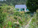 Garten mit bunten Blumen und einem Haus im Hintergrund.