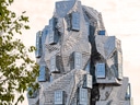 Moderne, skulpturale Gebäude mit versetzt angeordneten Fenstern.