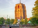 Alter Kirchturm in Leeuwarden, reflektiert im Wasser.