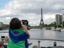 Person auf einem Boot fotografiert die Skyline einer Stadt mit Turm.