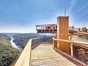 Aussichtsplattform über Flusstal in bewaldeter Landschaft.