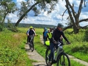 Radfahrer auf einem ländlichen Pfad unter blauem Himmel.