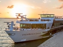 Kreuzfahrtschiff am Wasser bei Sonnenuntergang.
