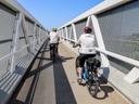 Zwei Radfahrer auf einer Brücke mit Gittern.