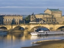 Schiffe auf der Elbe vor historischer Architektur und Brücke in Dresden.