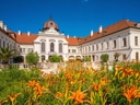 Barockpalast mit Garten voller orangefarbener Blumen.
