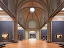 Innenansicht einer kunstvollen Museumshalle mit Gemälden.