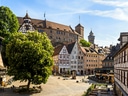 Historische Altstadt mit Fachwerkhäusern und Burg, sonniger Platz.