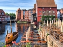 Fluss mit Holzboot und historische Gebäude, Lüneburg.
