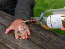Calvados wird in ein Glas auf Holztisch gegossen.