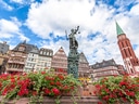 Historische Gebäude und Brunnen mit Blumen in Frankfurt.