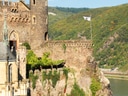 Mittelalterliche Burg auf Klippe über Flusslandschaft.