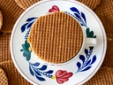 Stroopwafel auf einer Tasse auf bemaltem Unterteller.