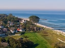 Luftaufnahme einer Küstenlandschaft mit Häusern und Strand.