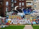Wand mit buntem Graffiti in urbaner Umgebung.