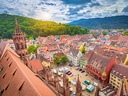 Luftbild von Freiburg mit historischem Münster und bunten Häusern.