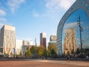 Platz mit modernen Gebäuden und Glasfassaden im Hintergrund.