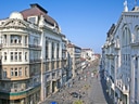 Blick auf architektonische Gebäude und belebte Strasse bei klarem Himmel.