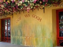 Gelbes Café Van Gogh mit Blumen an der Fassade.