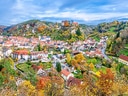 Herbstliche Landschaft mit Dorf und buntem Laub.