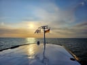 Blick von einem Schiff auf die See bei Sonnenuntergang.