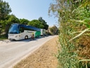 Bus mit Fahrradfahrer auf ländlicher Strasse.