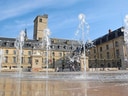 Wassertöne vor historischem Gebäude und Turm.