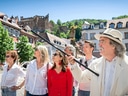 Gruppe mit Stadtführer vor historischer Kulisse.