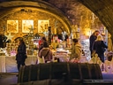 Menschen an einem geschmückten Weihnachtsmarktstand in einem Gewölbekeller.