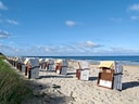 Strandkörbe am Sandstrand vor dem Meer.
