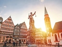 Fachwerkhäuser und Justitia-Statue in Frankfurt am Main bei Sonnenuntergang.