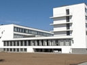 Weisse, moderne Gebäude mit flachen Dächern und grossen Fenstern.