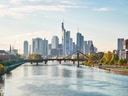Skyline von Wolkenkratzern hinter Fluss und Brücke bei Tageslicht.