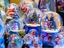 Verschiedene Schneekugeln mit weihnachtlichen Szenen.