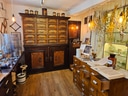 Innenraum einer alten Apotheke mit Holzmöbeln und Heilkräutern.